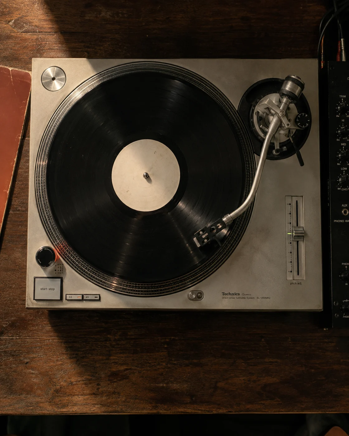 An overhead view of a well-used silver turntable with a record ready to play